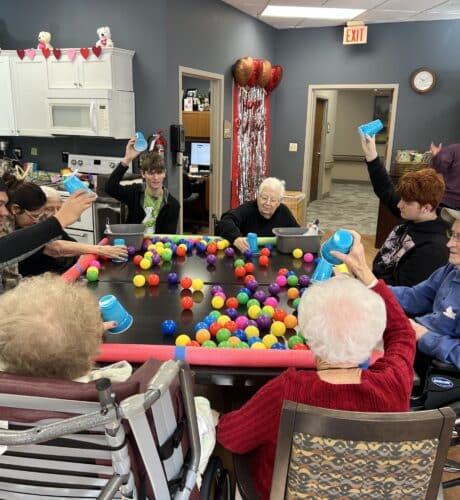 group of seniors and team members playing with balls and pool pipes