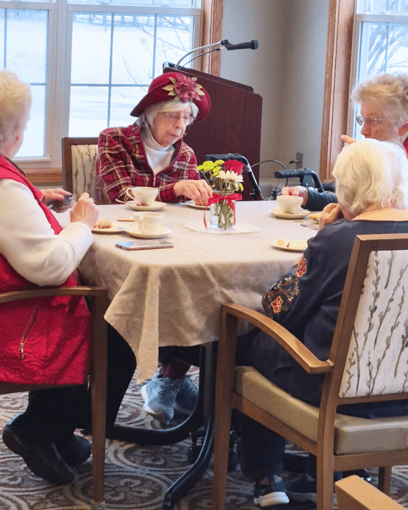 community living 4 elder women eating biscuit and drinking tea