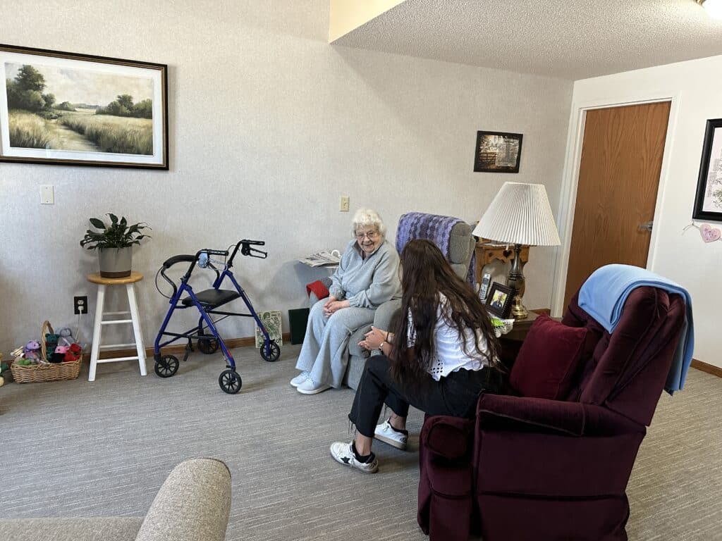 resident chatting with aid in room