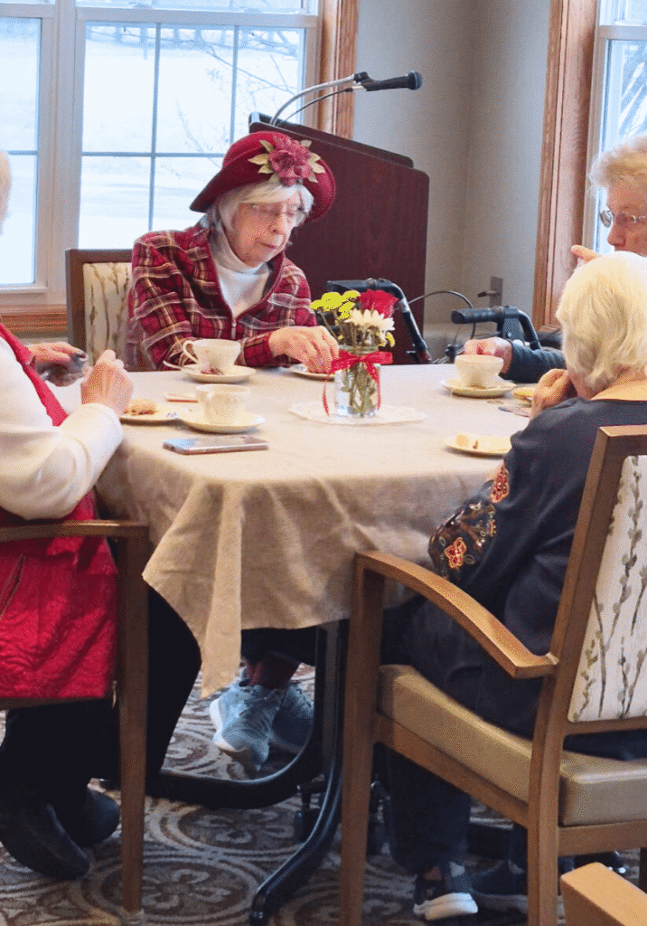 community living 4 elder women eating biscuit and drinking tea