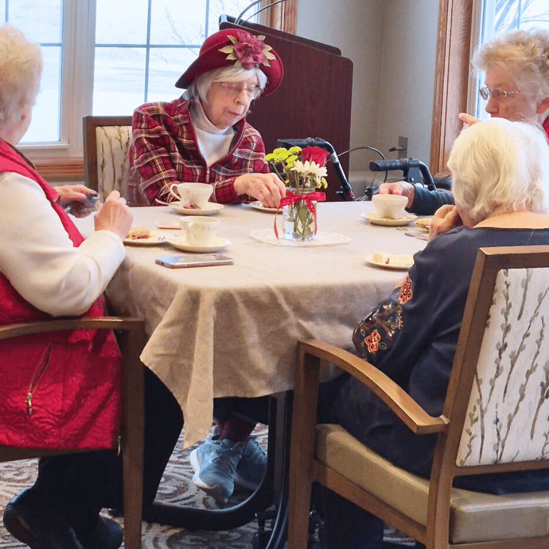 community living 4 elder women eating biscuit and drinking tea