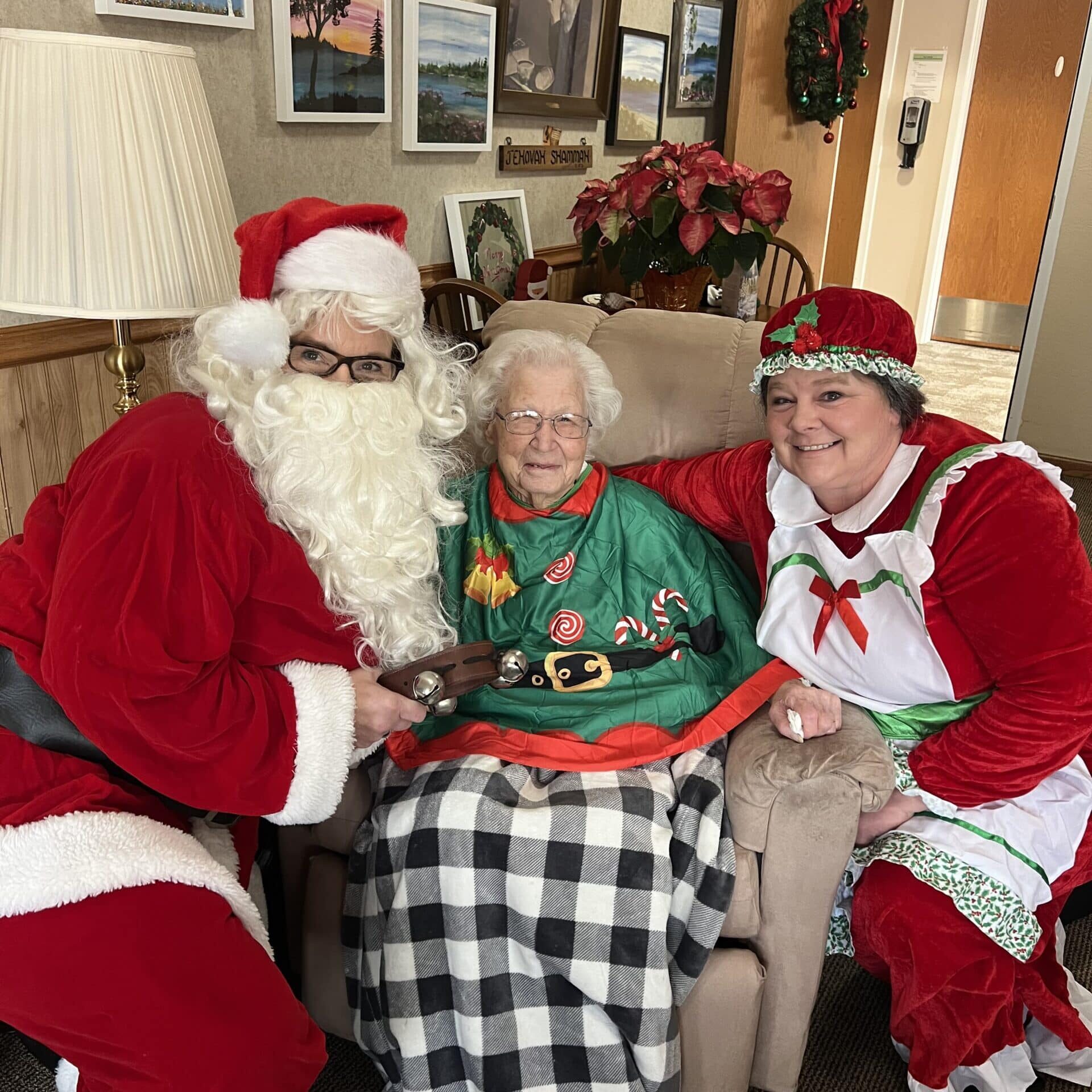 elder posing with santa clause and misses clause