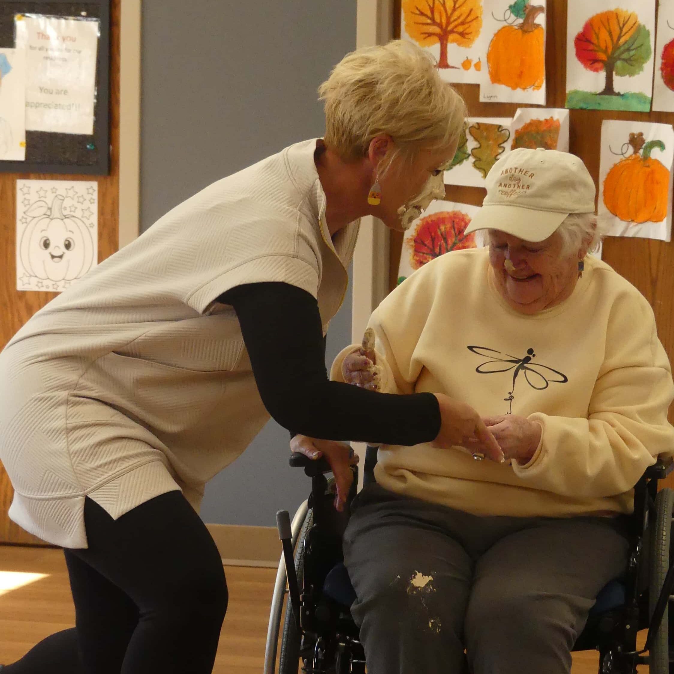 joy helping an elder to stand up from a wheel chair