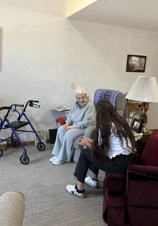 resident chatting with aid in room