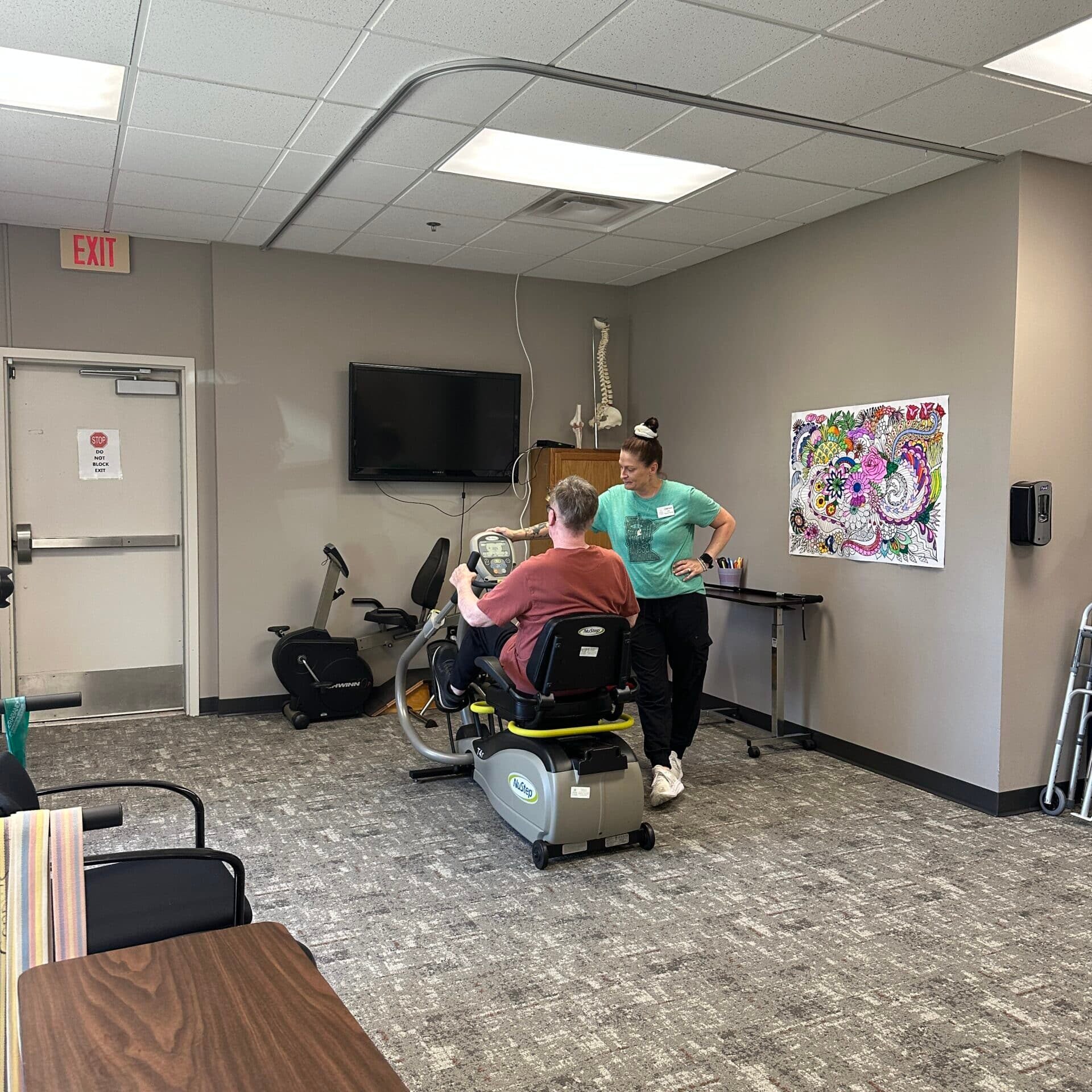 staff helping person on exercise bike at rehabilitation facility