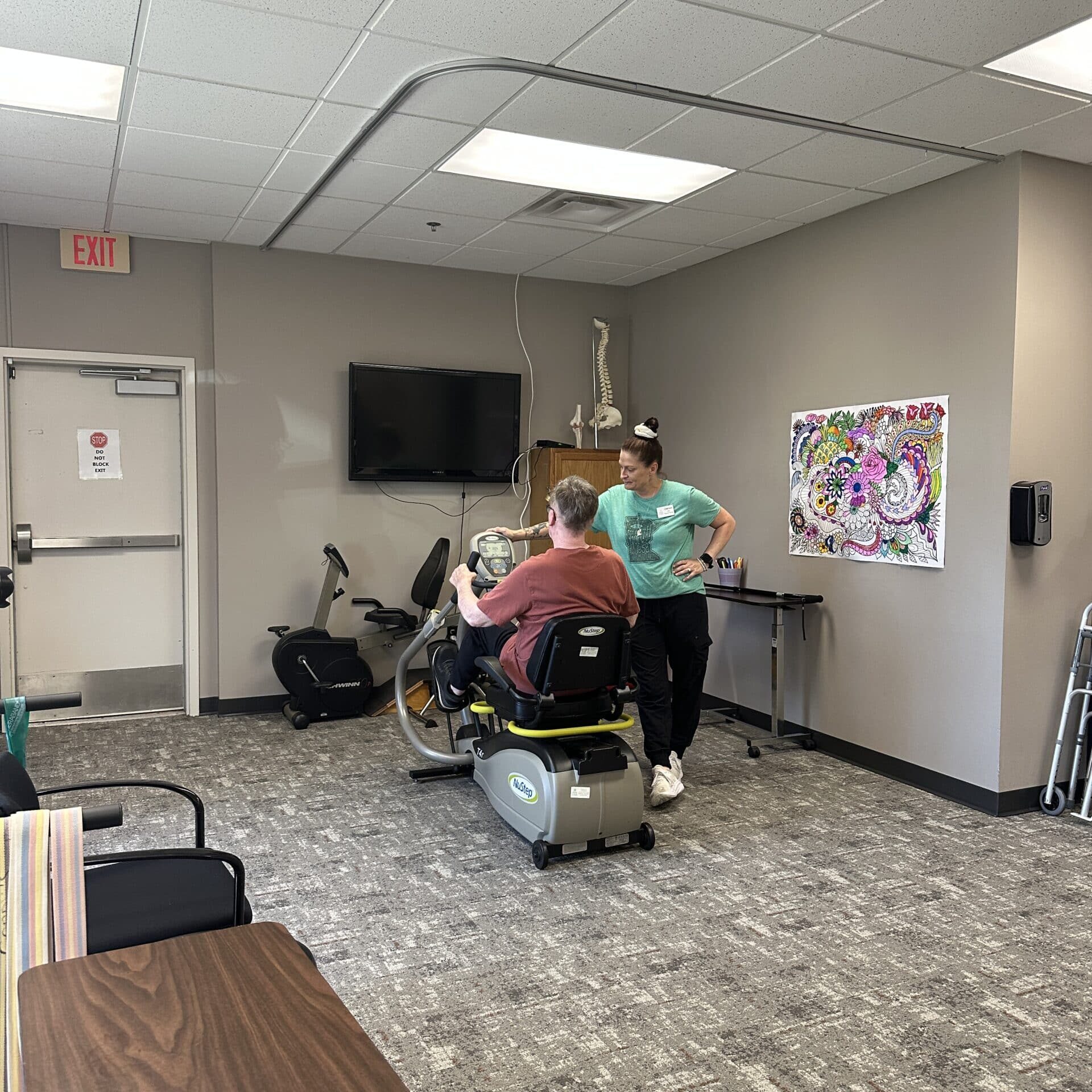 staff helping person on exercise bike at rehabilitation facility